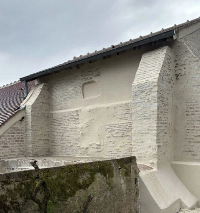 Maison moderne à façade blanche avec portes-fenêtres coulissantes, volets roulants et escalier en pierre