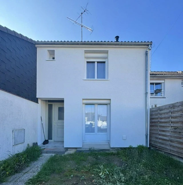 Façade de bâtiment en pierre calcaire avec niches architecturales en relief, située dans un environnement extérieur avec végétation