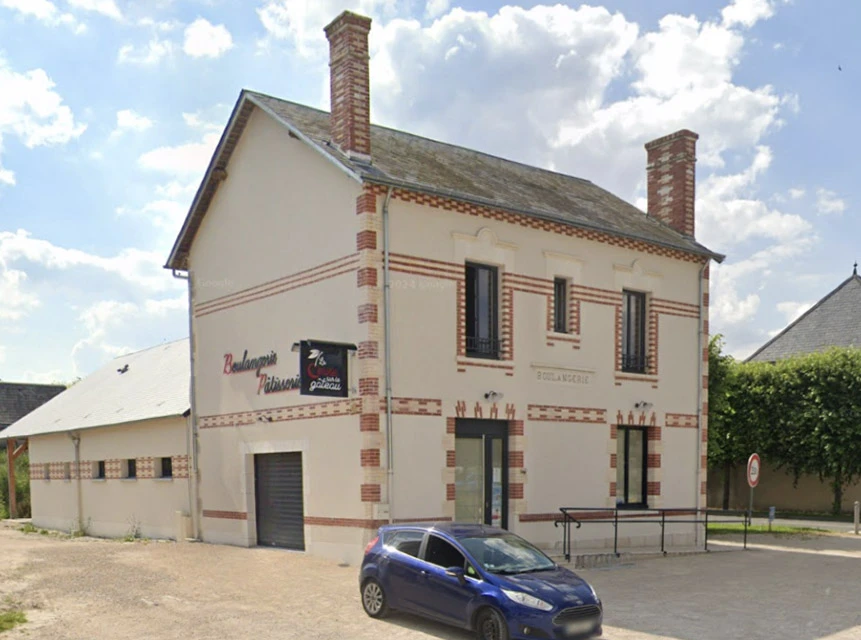 Maison individuelle contemporaine avec façade blanche, toiture en tuiles brunes et jardin engazonné